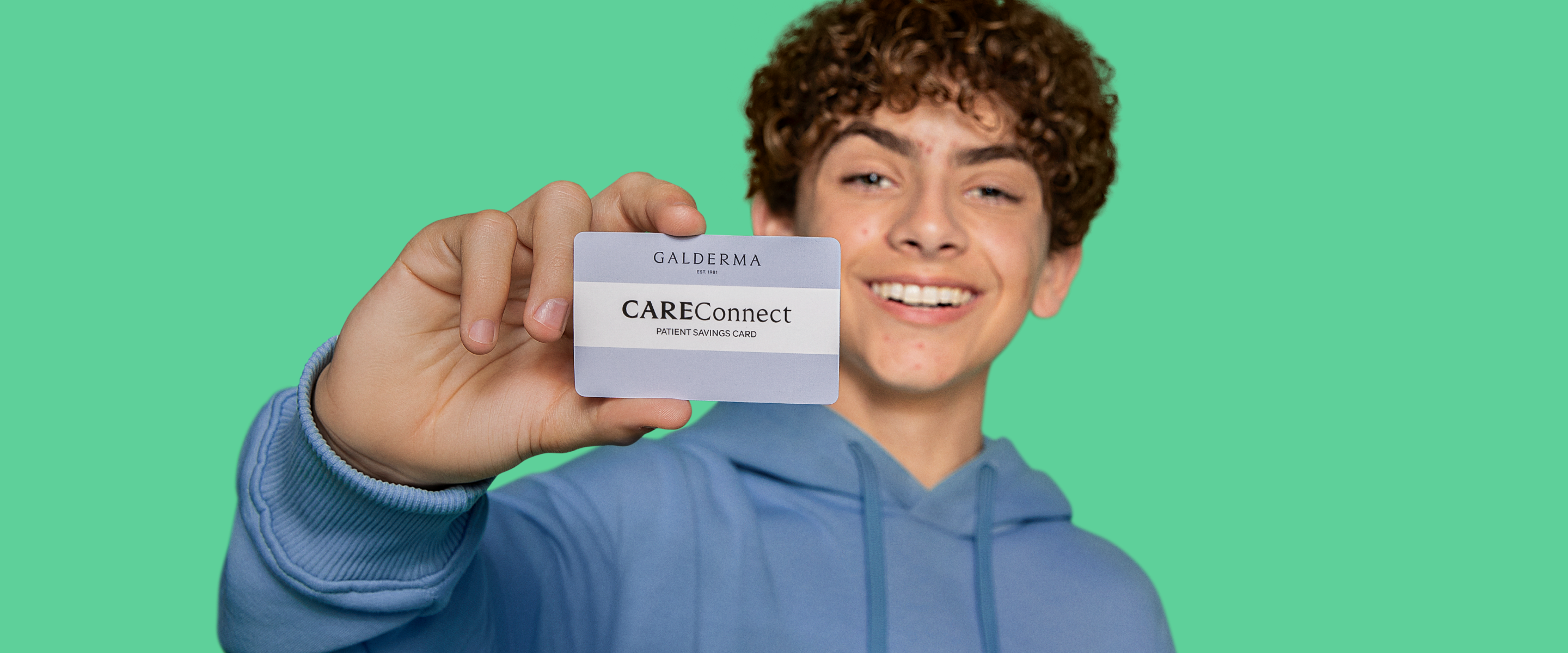 oung male teen holding the Galderma CareConnect card up in front of his face toward the camera.