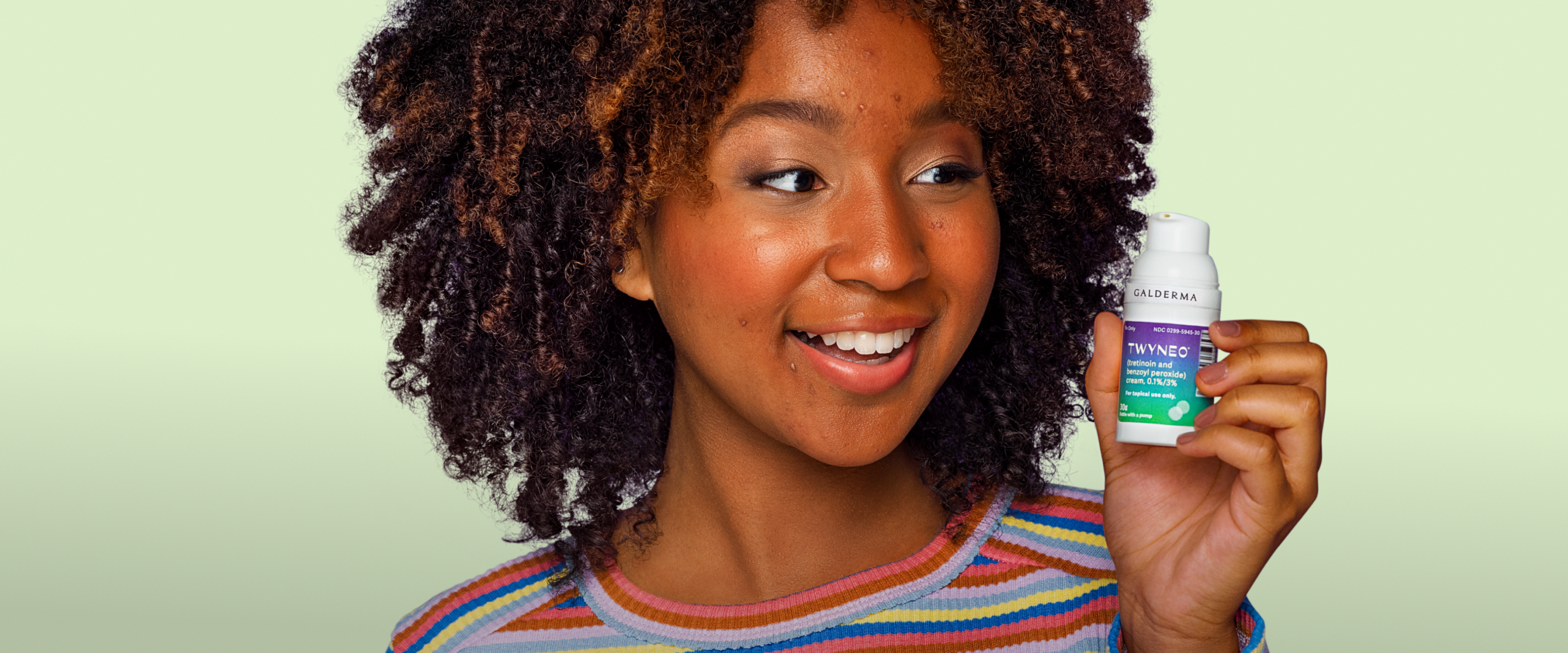 A close-up photo of a person holding the TWYNEO cream bottle close to their face.